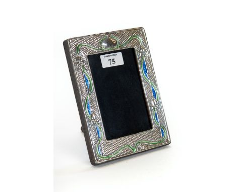 AN ART NOUVEAU INFLUENCE SILVER &amp; ENAMEL PHOTOGRAPH FRAME with embossed stylised flower &amp; tendril design, wooden back