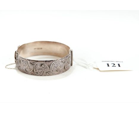 A MODERN SOLID SILVER FOLIATE SCROLL ENGRAVED HINGED BANGLE, fitted safety chain, maker: LW&amp;G, London 1975, approx 50 gra