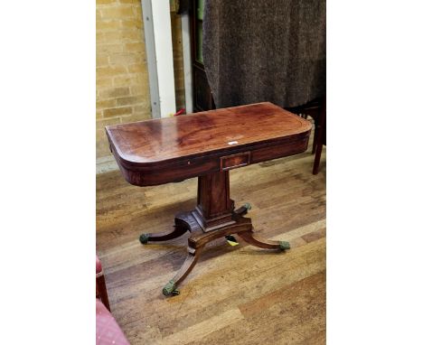 A REGENCY PERIOD MAHOGANY "D" SHAPED CARD TABLE, the ebony strung top above a panel centre frieze, raised on a panelled colum