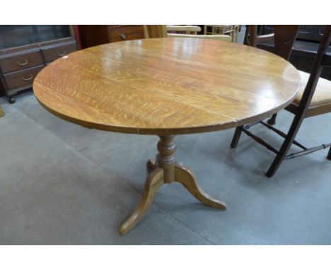 A George III style oak circular tilt-top tripod table