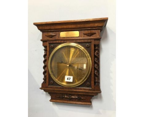 A wall mounted oak and barley twist barometer