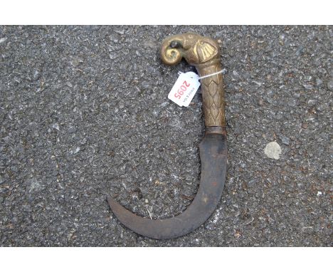 An Indian sickle shaped dagger, with elephant form copper hilt. 