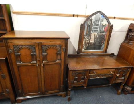 An early 20thC oak gentleman's wardrobe, with two carved panelled doors, raised on bracket feet, 87cm x 45.5cm x 119cm, and a