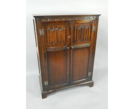 An oak gentleman's wardrobe, with linenfold panelled doors, raised on bracket feet, 87cm x 47.5cm x 118.5cm.