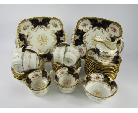 A Coalport porcelain late 19thC tea service, decorated with reserves of flowers against a cobalt blue ground, gilt heightened