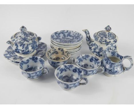 An early 19thC pottery child's part tea service, printed in flow blue with a floral sheet pattern, comprising teapot, cream j