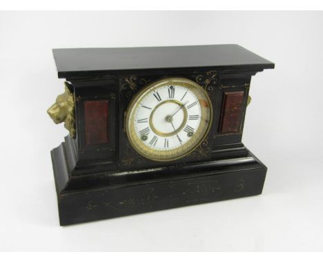 An Ansonia Clock Company cast iron and marble cased mantel clock, with lion's head handles, enamel dial bearing Roman numeral