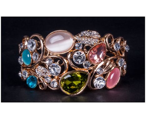 Crystal, 'Cat's Eye' and Gilt Openwork Cuff Bangle, a variety of stones in blue, green, peach and white in a random design on