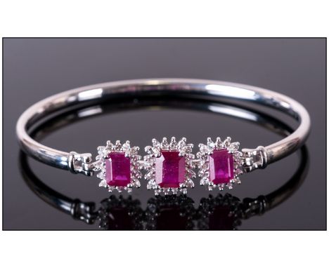 Ruby and White Topaz Bangle, three large octagon cut rubies, the largest, to the centre front being 2.5cts, each with a frame