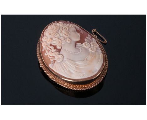 A Fine 9 carat Oval Framed Shell Cameo Brooch with portrait of a young woman in early 20thC dress. Fully hallmarked. 2 inches