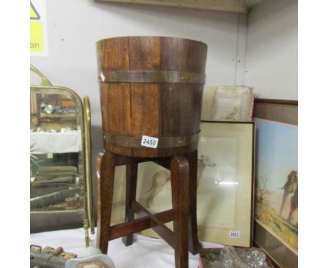 A brass bound planter on stand.