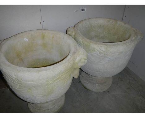 2 20th century garden urns on plinths.