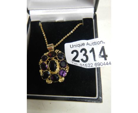 A Victorian mixed cut amethyst pendant in gold cannetille setting on yellow metal chain.The part that joins the pendant is ne