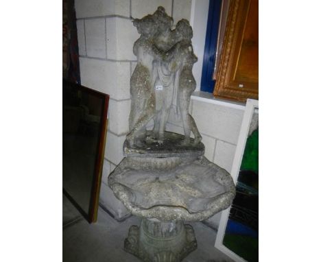 A garden statue of The Three Graces on shell and base.
