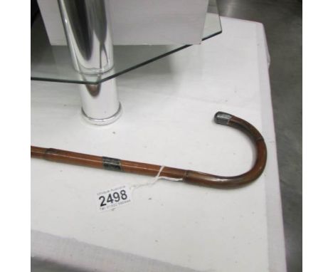 A bamboo walking cane with silver tip.