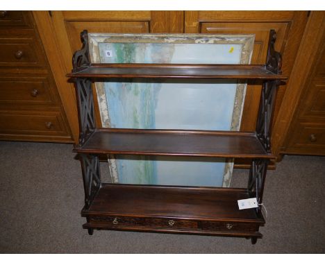 A reproduction mahogany Chinese Chippendale style wall mounted shelf unit, the base fitted with three shallow drawers with ca