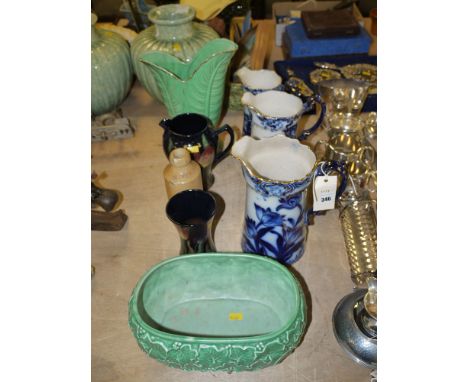 A set of three graduating blue and white ware jugs; a green ware leaf pattern vase, inscribed on the base 'Mary Leigh'; a Syl