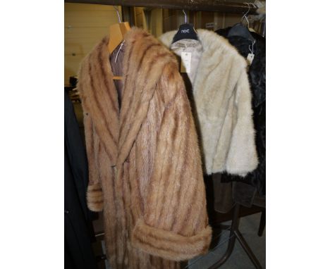 A lady's light coloured three-quarter length fur coat; and a lady's cream coloured fur cape.