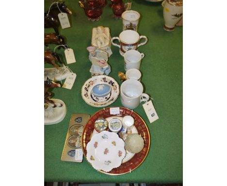 A pair of Continental ware ornaments modelled as children standing beside baskets; and another similar ornament modelled as a