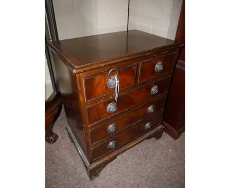 A miniature reproduction mahogany chest of two short and three long drawers with ring pull handles, raised on  bracket feet.