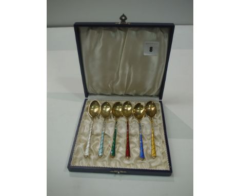 A set of six silver gilt teaspoons by Ela, Denmark, with coloured enamel handles (damages), in fitted case.
