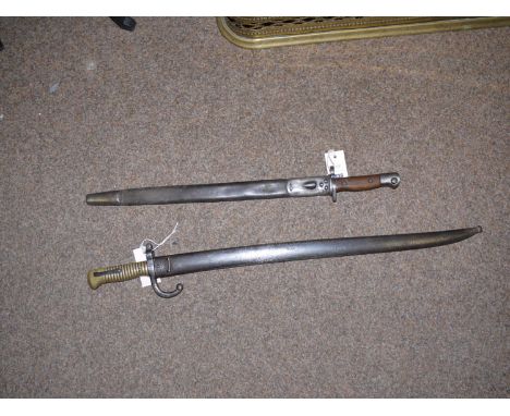 A 19th Century French bayonet and scabbard; and an English WWI bayonet and scabbard.