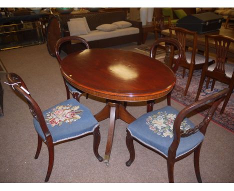 A set of four Victorian mahogany balloon back dining chairs, the seats upholstered in blue floral pattern tapestry, raised on