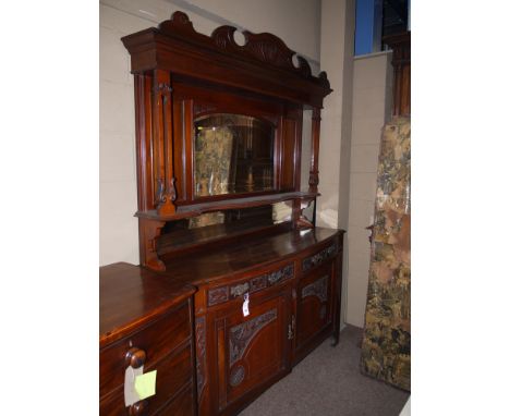 A Victorian carved and stained walnut mirror back sideboard, the back panel with overhanging decorative carved cornice suppor