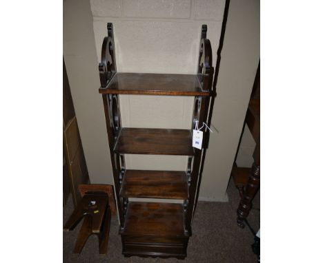 A reproduction mahogany tall narrow shelf unit, with four shelves, decorative pierced sides, fitted two shallow drawers in th