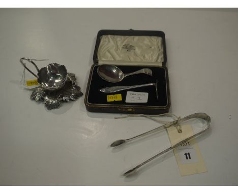 A white metal egg cup by Walker & Hall, of flower and leaf pattern; together with a pair of Georgian silver sugar tongs, brig