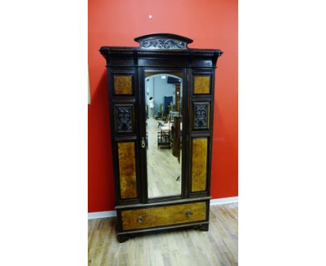 A late Victorian mahogany wardrobe having a bevel edge mirror door enclosing fitted interior over long drawer raised on brack