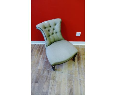 A late Victorian button back nursing chair, raised on turned supports & stretchers.
