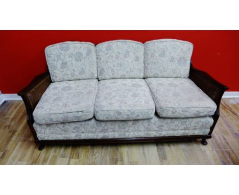 A 19th century mahogany framed Bergere suite to include two easy chairs and a three seater sofa