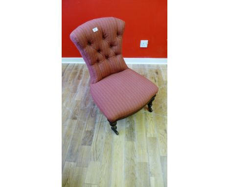 A Late Victorian nursing chair, having a button back over padded seat, raised on turned supports and castors.