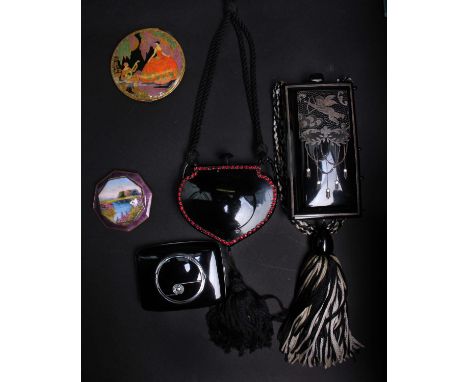An early 20th Century black plastic compact with an inlaid image of a cherub; a 1920s celluloid powder compact, a 1920s mauve