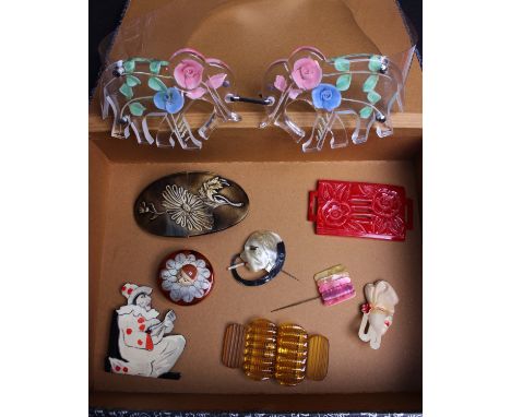 An early 20th Century plastic carved red buckle; a 1930s Art Deco hat pin, a French 1930s plastic compact box with clown head