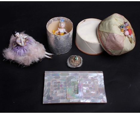 A 1920s china pin cushion lady wearing a mauve silk dress edged in swansdown; a 1930s powder puff doll in original box, a 193