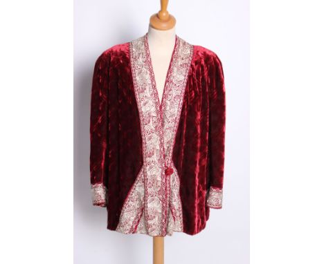 An early 20th Century red silk velvet evening jacket edged with  a border of silver silk Chinese embroidery by John Field and