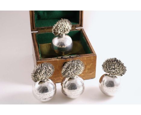 REGIMENTAL INTEREST:- A cased set of four late Victorian parcelgilt table lighters, each in the form of a grenade with "flami