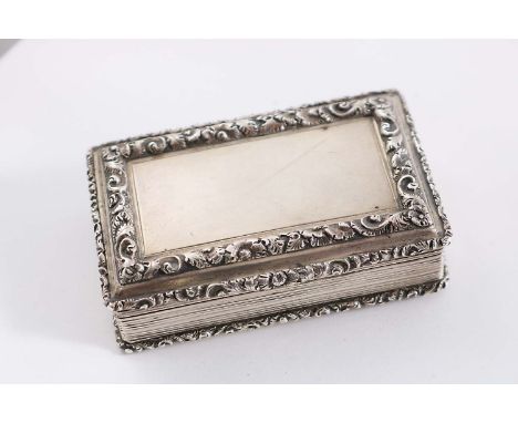 A WILLIAM IV RECTANGULAR SNUFF BOX with raised floral borders, reeded base & sides and a vacant rectangular cartouche on the 