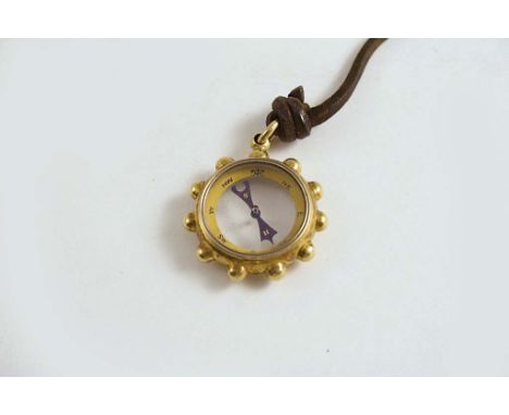 AN 18 CT. GOLD PENDANT in the form of a compass with glazed centre;  3 cms dia.
