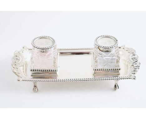 A LATE VICTORIAN/EDWARDIAN INKSTAND rectangular with shaped ends, gadroon & foliate shell borders and ball & claw feet, fitte