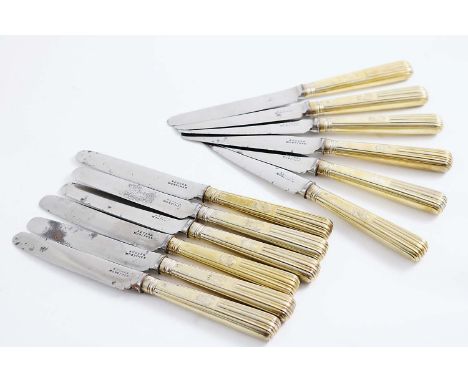 A MATCHED SET OF TWELVE GEORGE III / GEORGE IV SILVERGILT SIDE KNIVES with part-reeded handles, crested (steel blades) by var