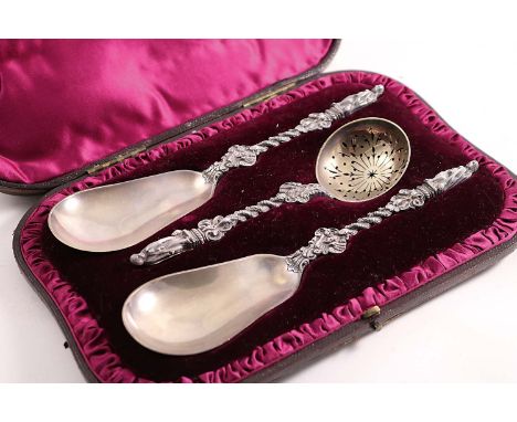A LATE VICTORIAN CASED PAIR OF FRUIT SERVING SPOONS and a matching sugar sifter ladle with figural terminals, by Edward Hutto