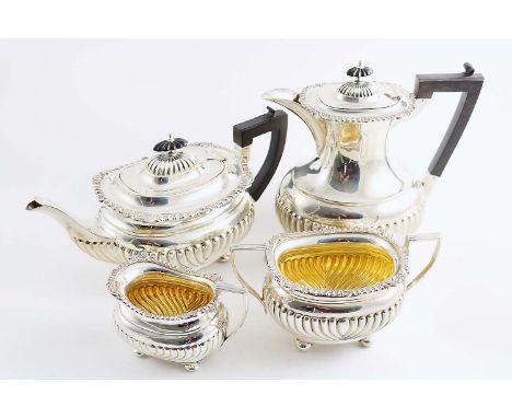 AN EDWARDIAN FOUR-PIECE TEA &amp; COFFEE SERVICE with part-fluted, rounded oblong bodies, bun feet and decorative borders, by