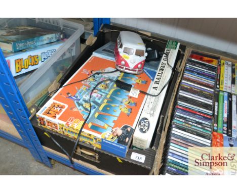 A box containing various jigsaw puzzles and a VW camper lamp