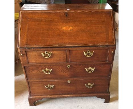 A George III oak Bureau, the interior fitted with small drawers, pigeonholes and shell inlaid cupboard, with an inlaid hinged