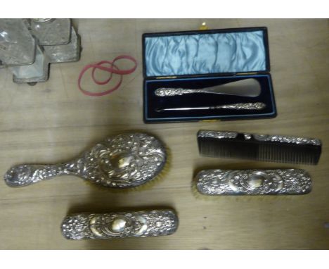 A silver backed four piece Dressing Table Set, and a Shoe Horn and Button Hook with silver handles in case.