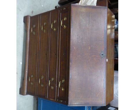 A George III Bureau, the hinged fall with mahogany cross banding and a fitted interior with four long graduated drawers under