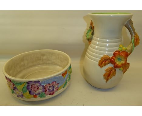 A Newport Pottery Clarice Cliff Fruit Bowl decorated with a continuous band of raised flowers fruit and peacocks.  7 1/2" (19